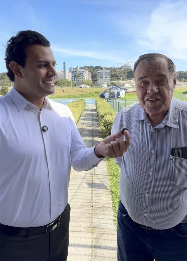 Daniel conversando com um senhor ao lado de um heliponto